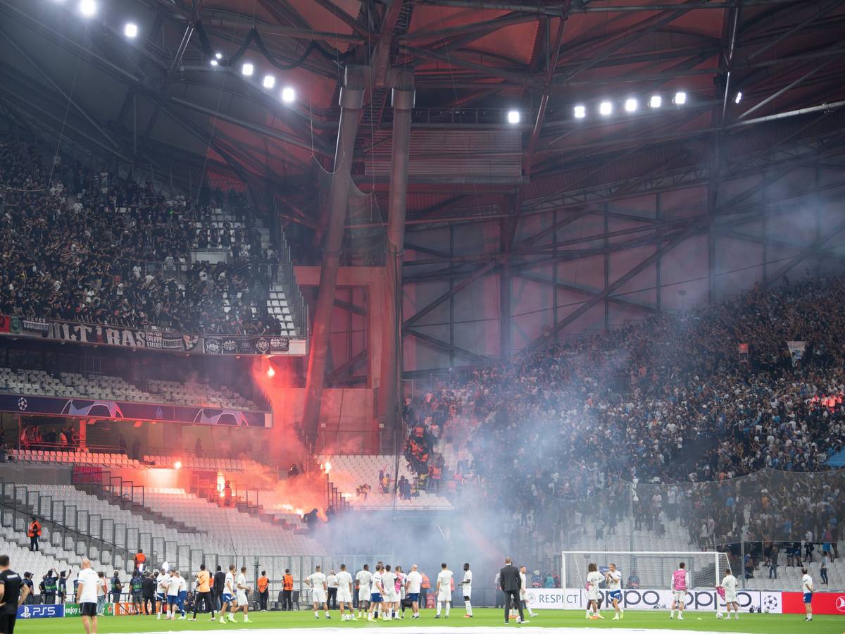 Die Blöcke der Ultras der Eintracht (l) und von Marseille beschießen sich mit Feuerwerk.