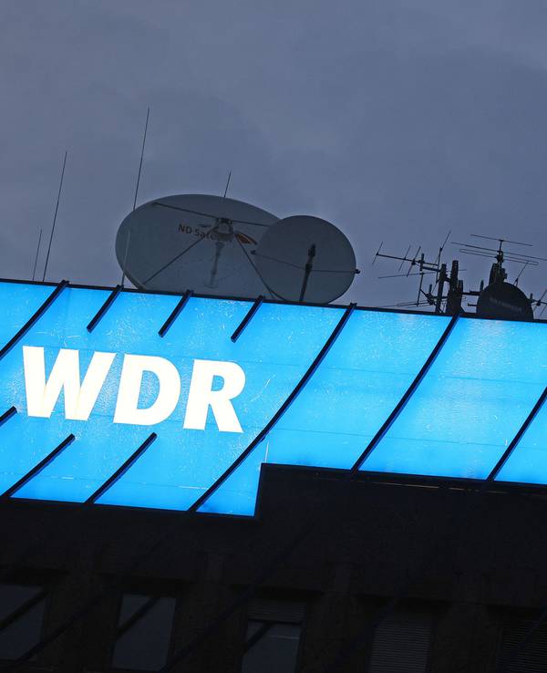 Ein Logo des WDR (Westdeutscher Rundfunk) leuchtet auf dem Dach des Senders.