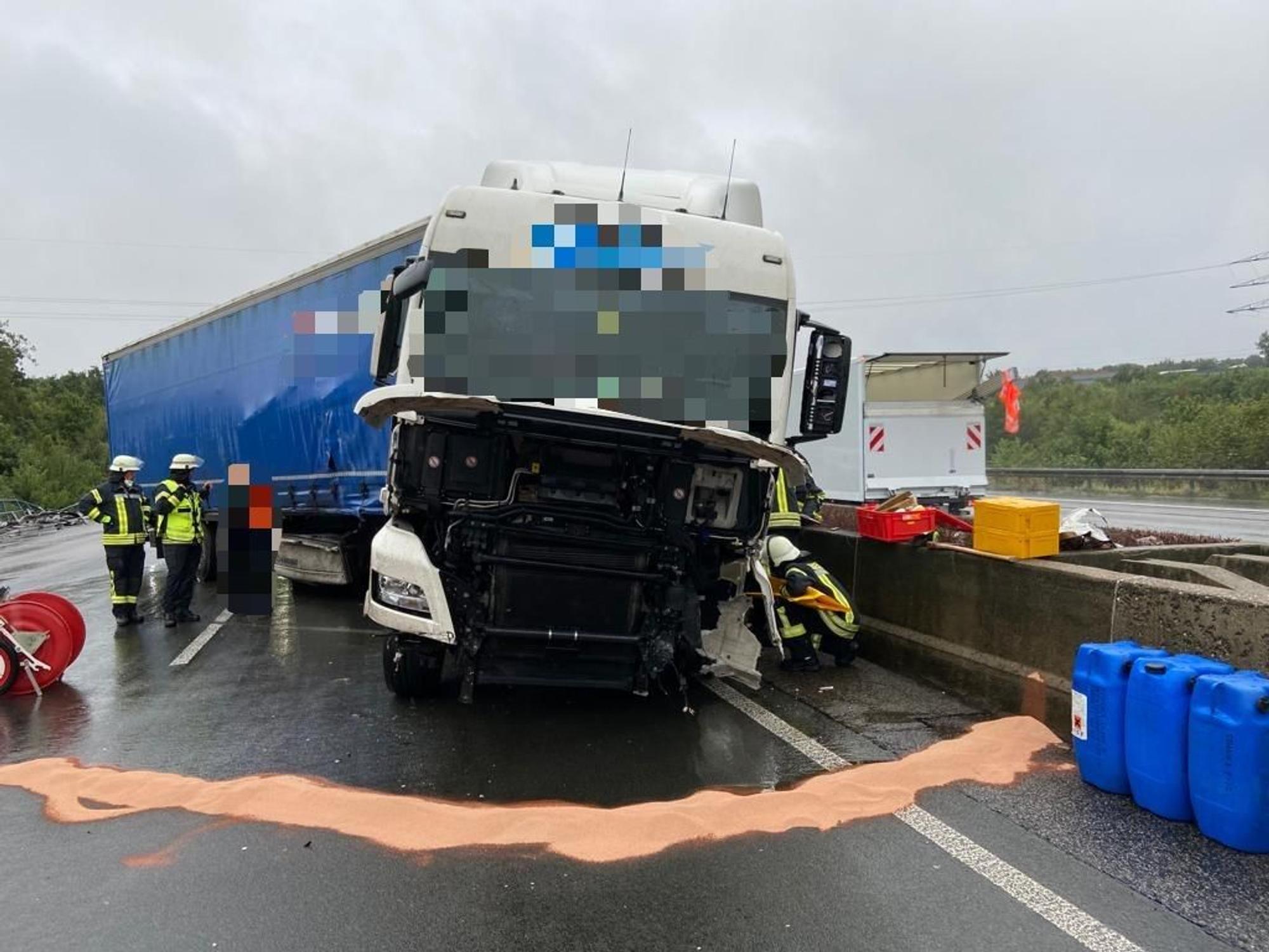 Beschädigter Lkw steht nach einem Unfall auf der Autobahn und wird von Einsatzkräften bearbeitet.