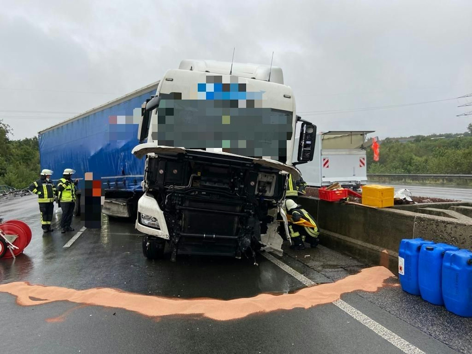 Beschädigter Lkw steht nach einem Unfall auf der Autobahn und wird von Einsatzkräften bearbeitet.