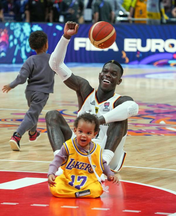 Dennis Schröder (Deutschland) sitzt nach dem Spiel mit seinen beiden Kindern auf dem Spielfeld.