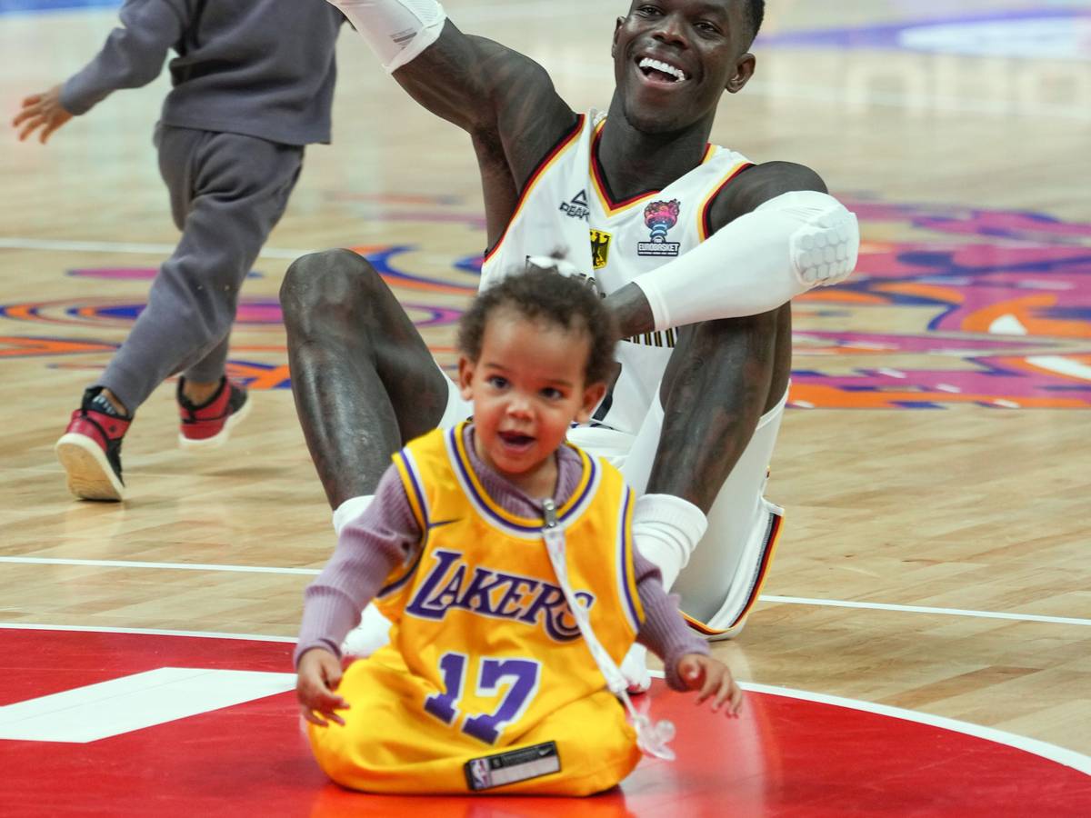 Dennis Schröder (Deutschland) sitzt nach dem Spiel mit seinen beiden Kindern auf dem Spielfeld.