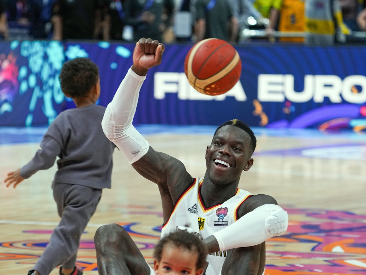 Dennis Schröder (Deutschland) sitzt nach dem Spiel mit seinen beiden Kindern auf dem Spielfeld.
