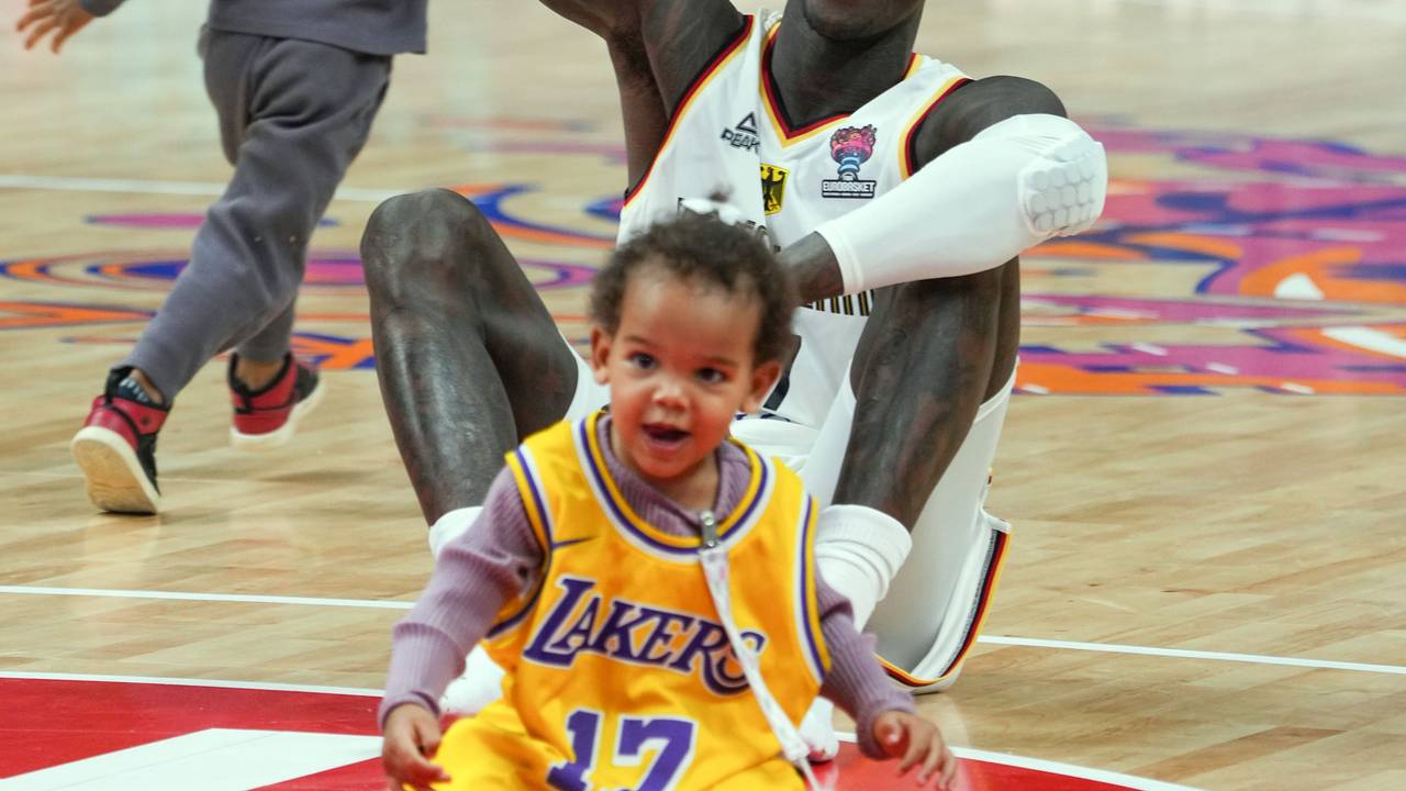 Dennis Schröder (Deutschland) sitzt nach dem Spiel mit seinen beiden Kindern auf dem Spielfeld.