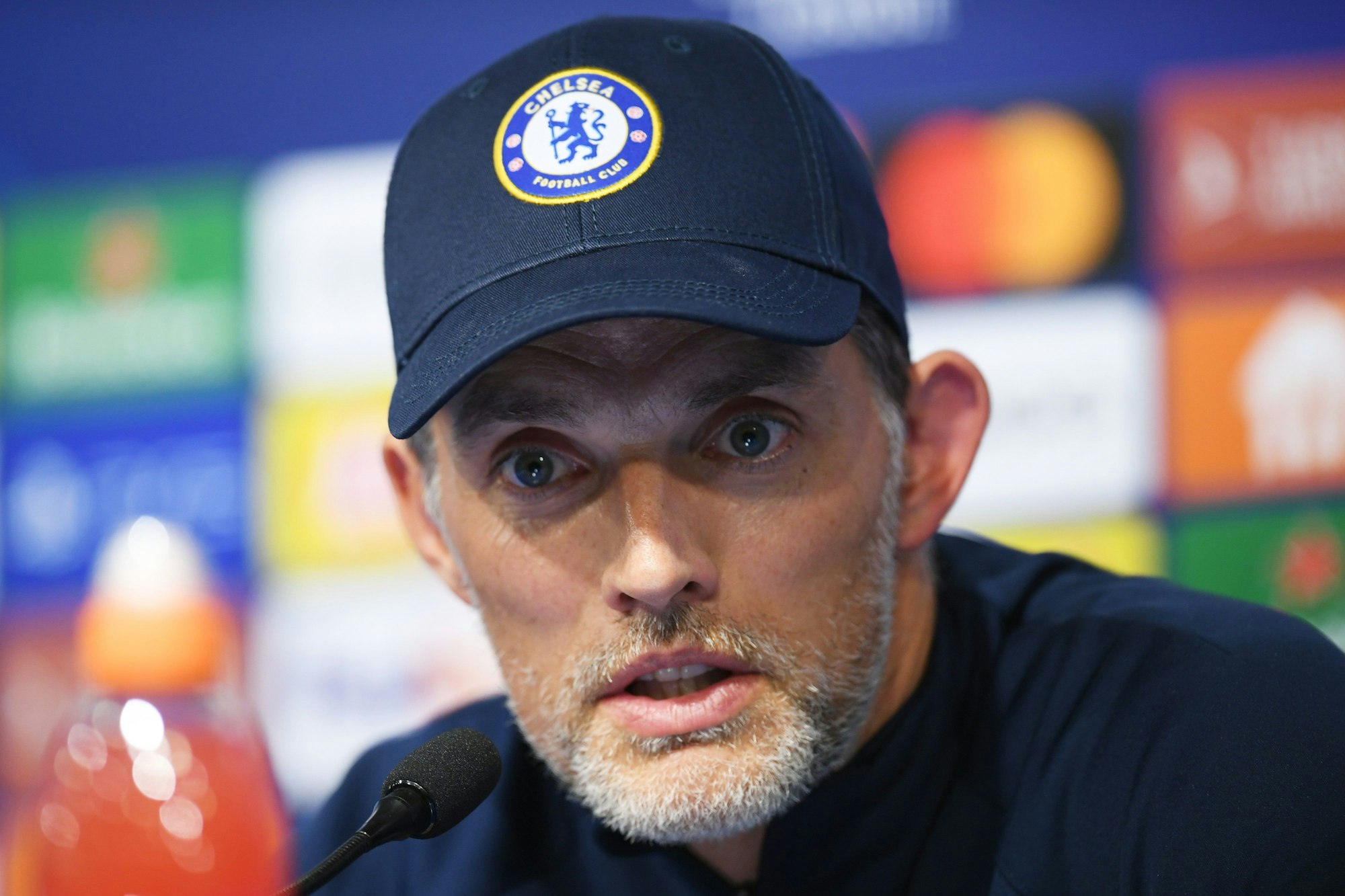 Thomas Tuchel sitzt bei einer Pressekonferenz am Rednerpult.