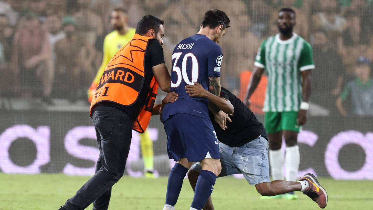 Ein Flitzer umarmt Lionel Messi während des Spiels von Paris St. Germain bei Maccabi Haifa. Ein Ordner versucht die beiden voneinander zu trennen.