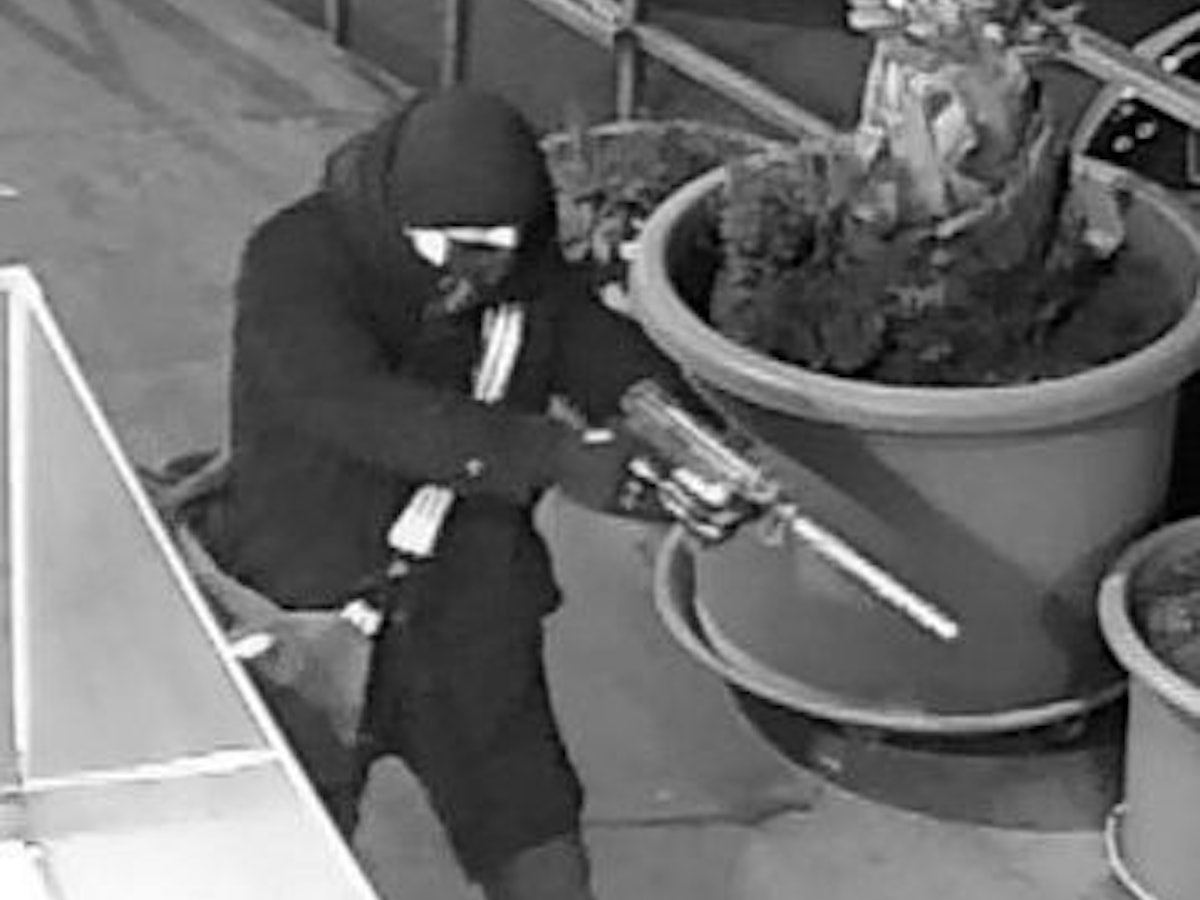 Ein maskierter Mann zielt mit einer Pistole.