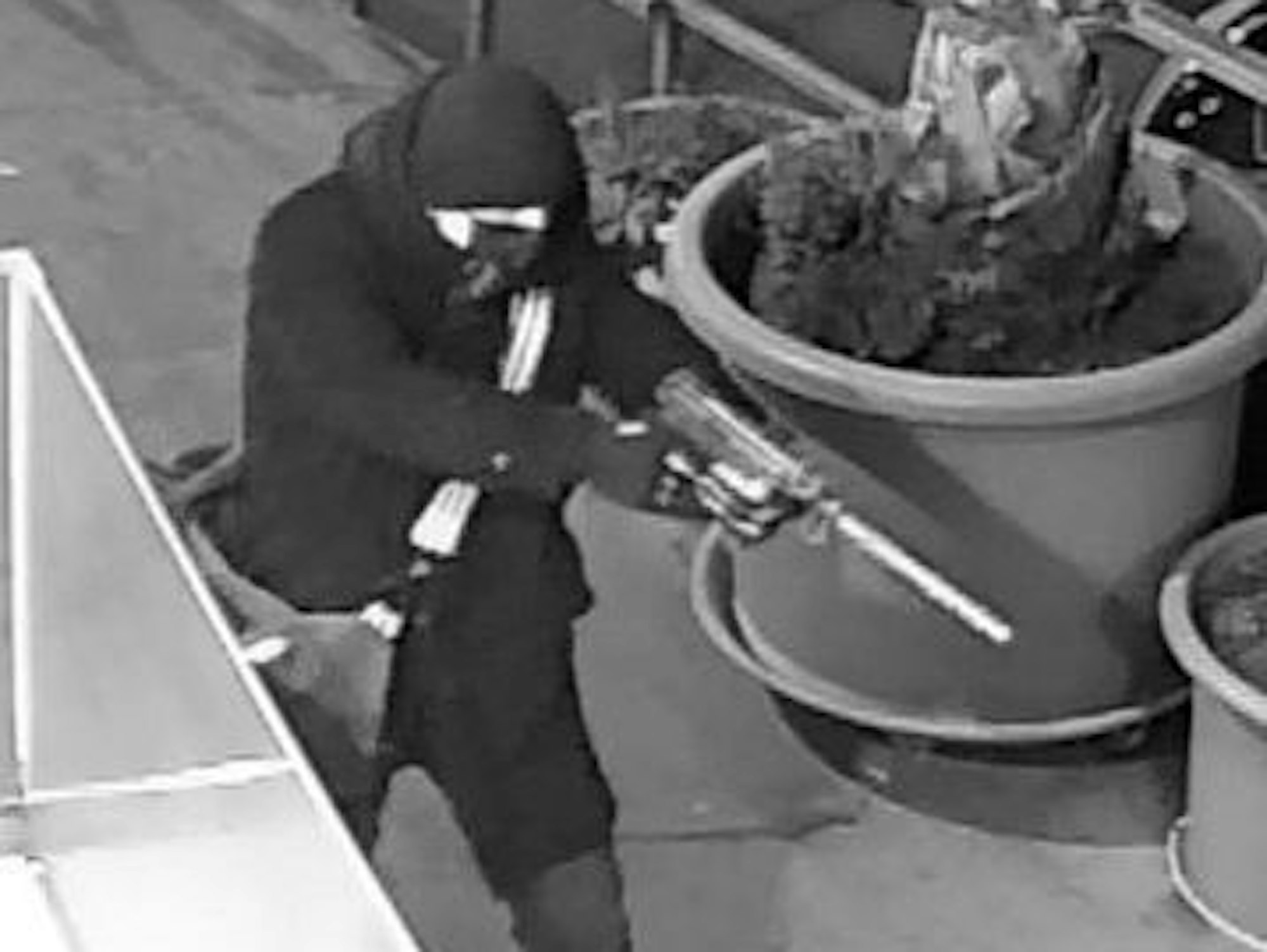 Ein maskierter Mann zielt mit einer Pistole.