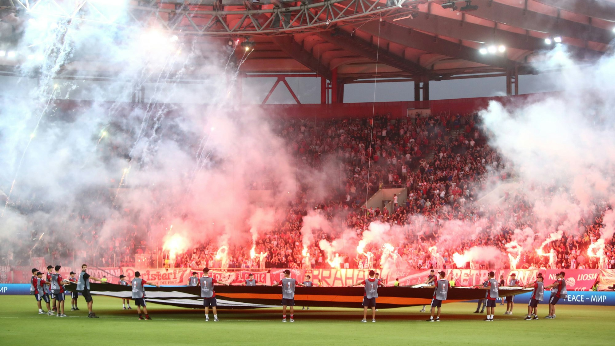 Fans von Olympiakos Piräus zünden vor dem Anpfiff der Europa-League-Partie gegen den SC Freiburg Pyrotechnik auf den Rängen