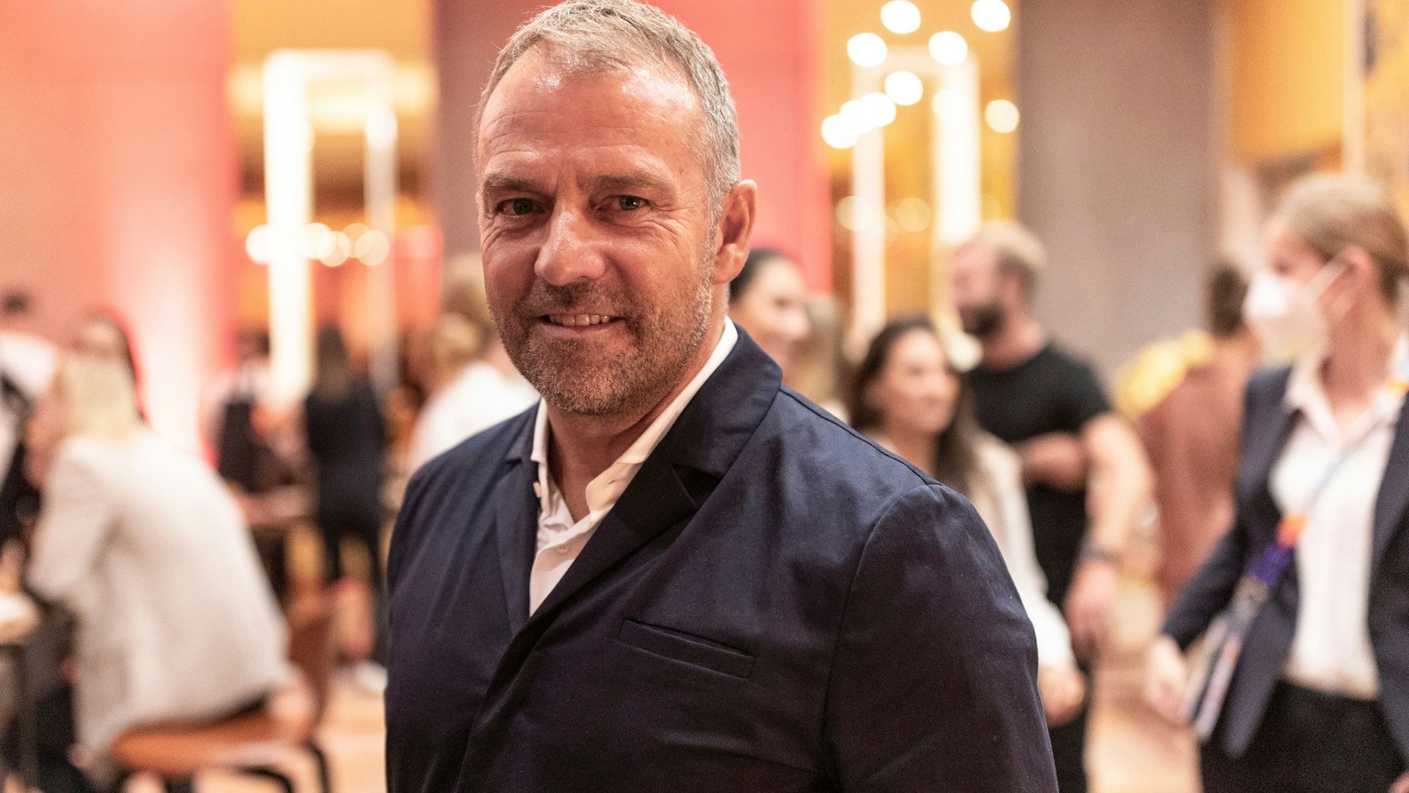 Bundestrainer Hansi Flick lächelt in die Kamera.