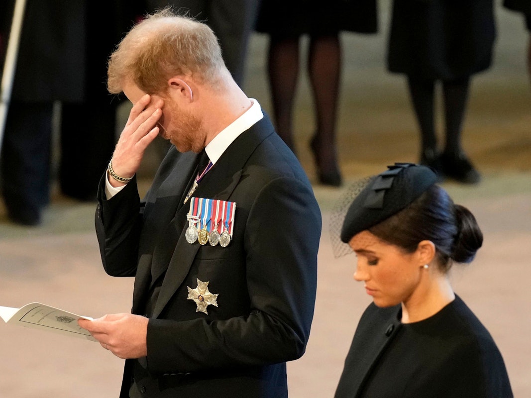 Das Foto vom 14. September 2022 zeigt Prinz Harry und seine Frau Meghan in Westminster Hall. Beide sind schwarz gekleidet und trauern.
