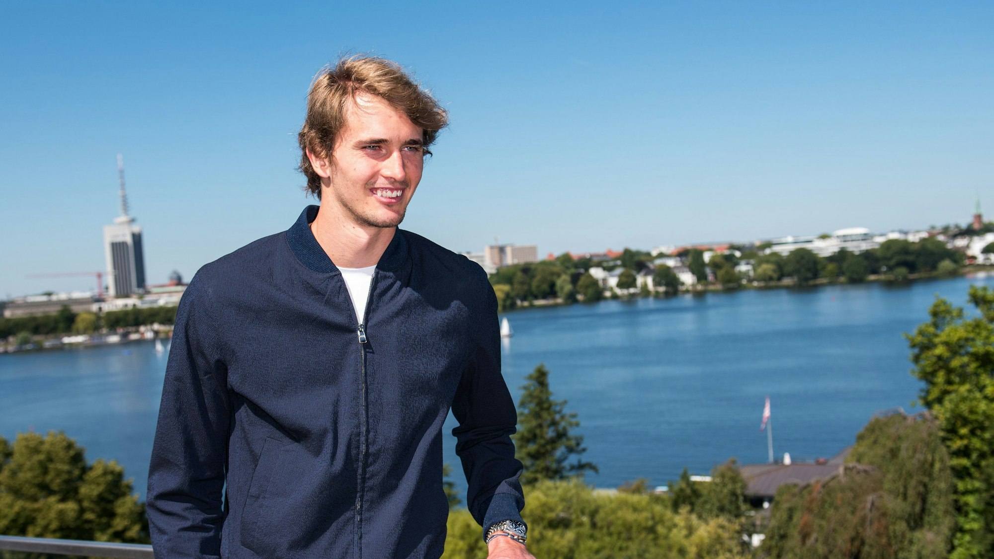 Tennis-Spieler Alexander Zverev steht am 11. August 2022 lachend an der Hamburger Alster.