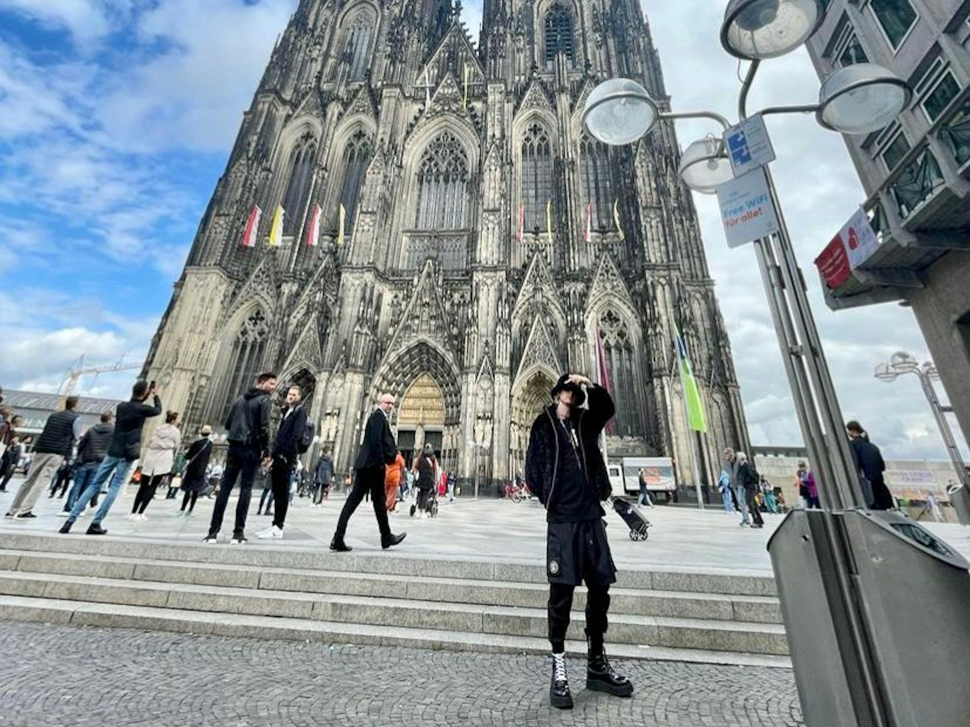 Machine Gun Kelly steht vor dem Kölner Dom.