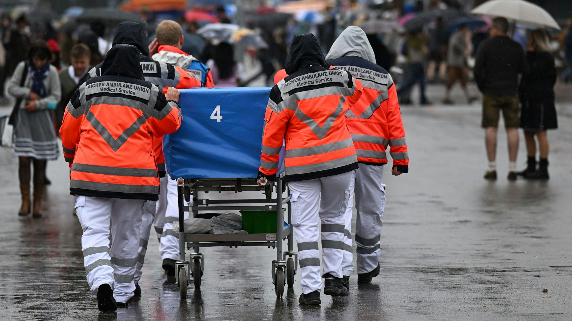 Start des 187. Münchner Oktoberfests auf der Theresienwiese: medizinisches Personal versorgt auf einer Trage einen Wiesn-Besucher.
