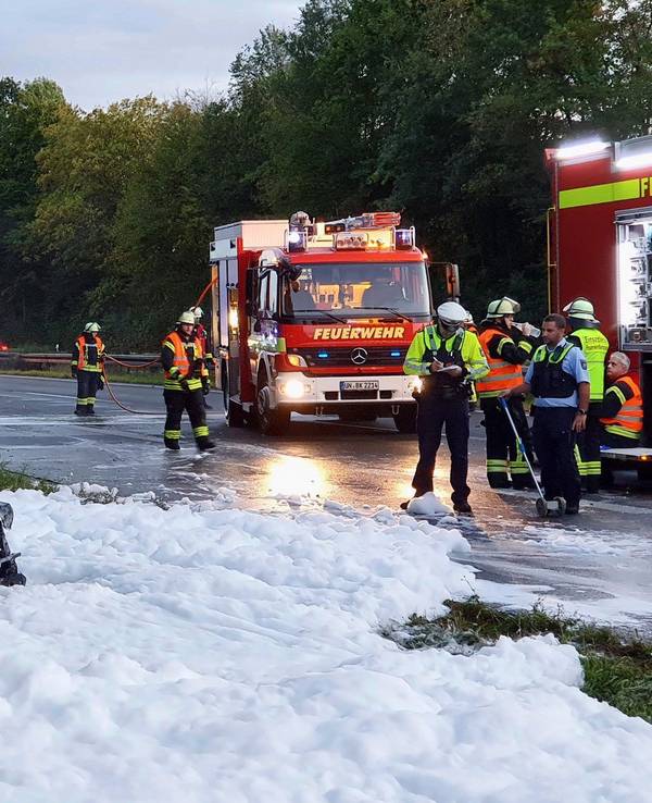 Das nach dem Unfall völlig ausgebrannte Autowrack steht noch in einem See aus Löschschaum neben der Autobahn A1.