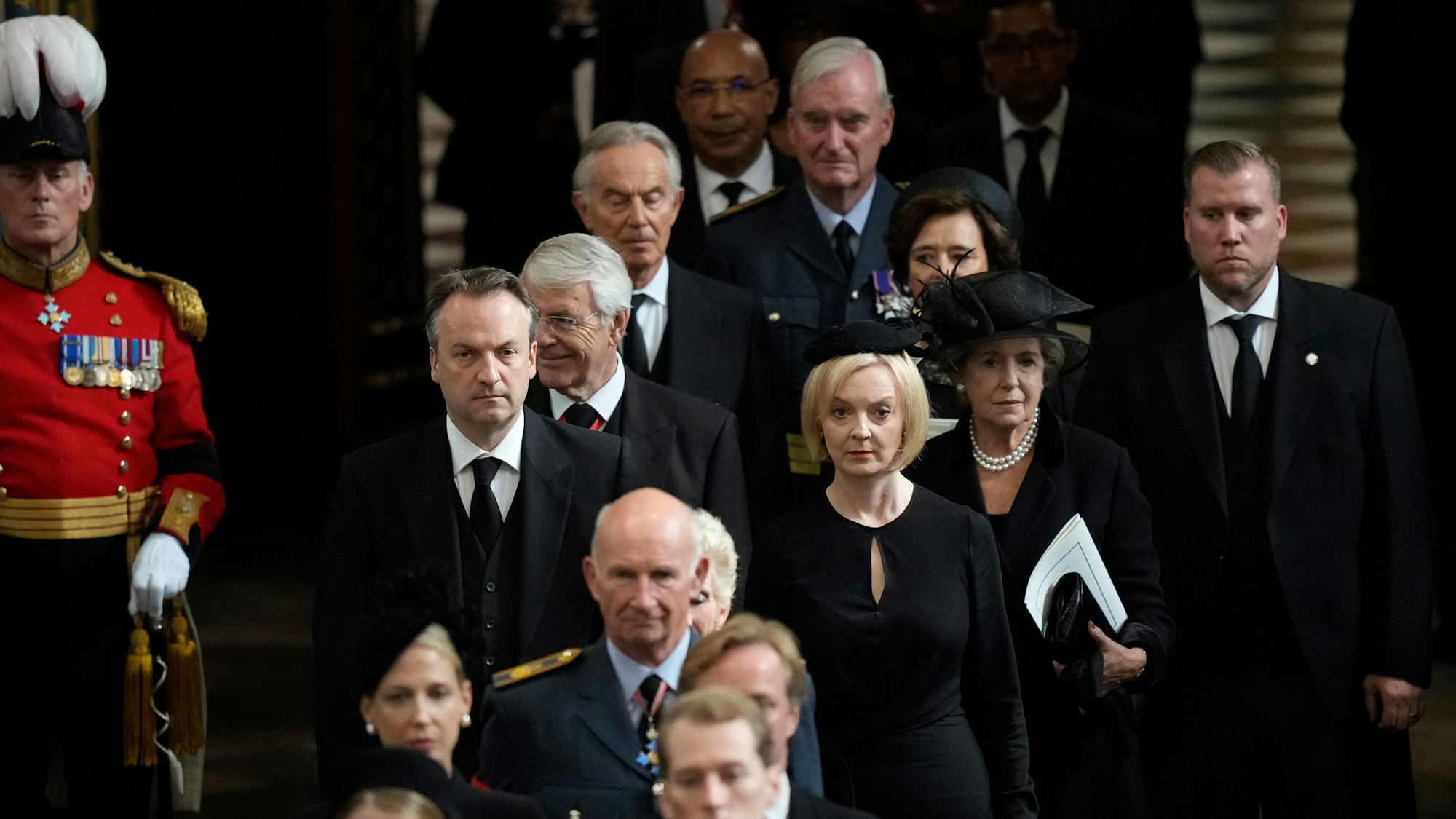 Liz Truss (M), Premierministerin von Großbritannien, und ihr Ehemann Hugh O'Leary, verlassen die Westminster Abbey nach dem Staatsakt vor der Beisetzung von Königin Elizabeth II.