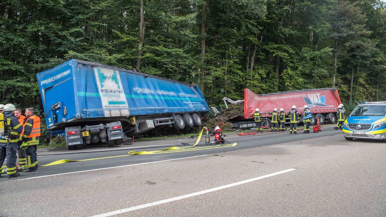 Zwei Lastwagen stehen nach einem Unfall am Fahrbahnrand einer Autobahn.