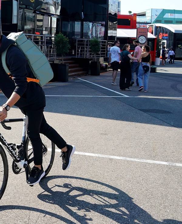 Mick Schumacher aus Deutschland von Team Haas fährt steigt im Fahrerlager von einem Fahrrad.
