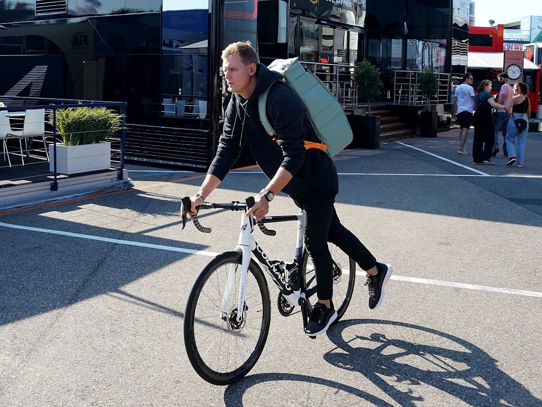 Mick Schumacher aus Deutschland von Team Haas fährt steigt im Fahrerlager von einem Fahrrad.