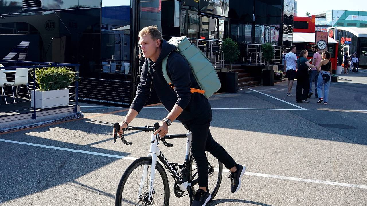 Mick Schumacher aus Deutschland von Team Haas fährt steigt im Fahrerlager von einem Fahrrad.