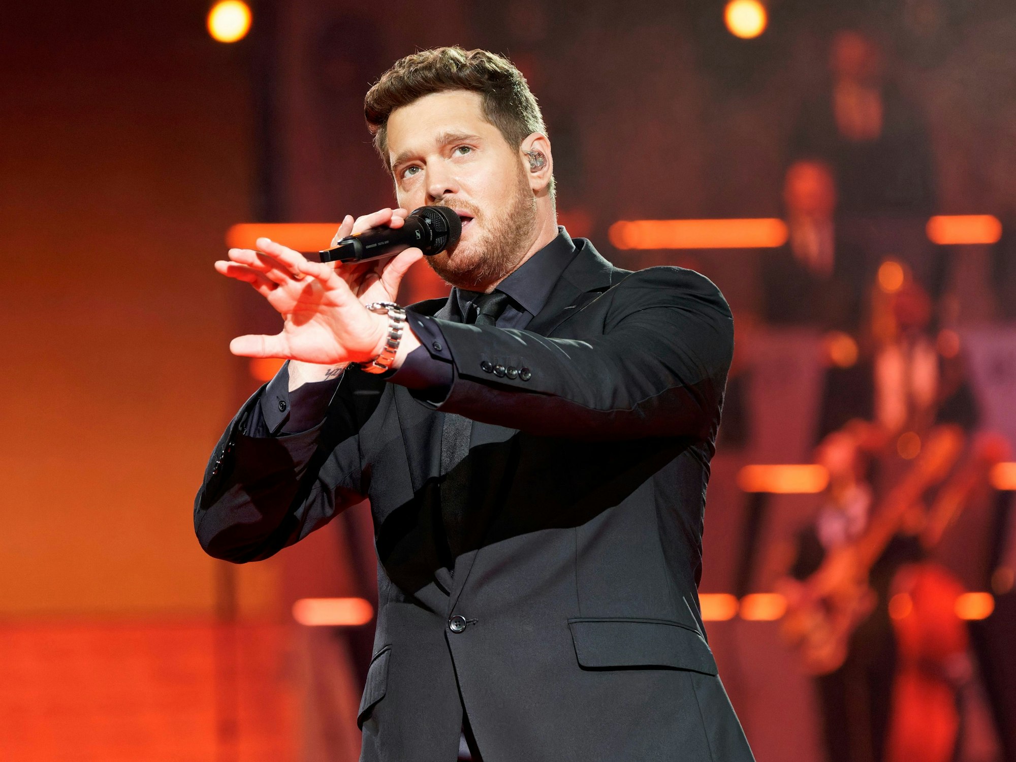 Michael Bublé sing mit Mikrofon auf der Bühne einen seiner Songs.