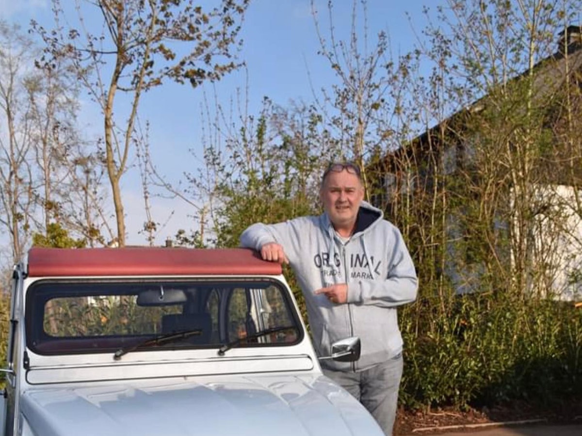 Auf dem Foto steht Waldi neben einem hellblauen Oldtimer und schaut in die Kamera.