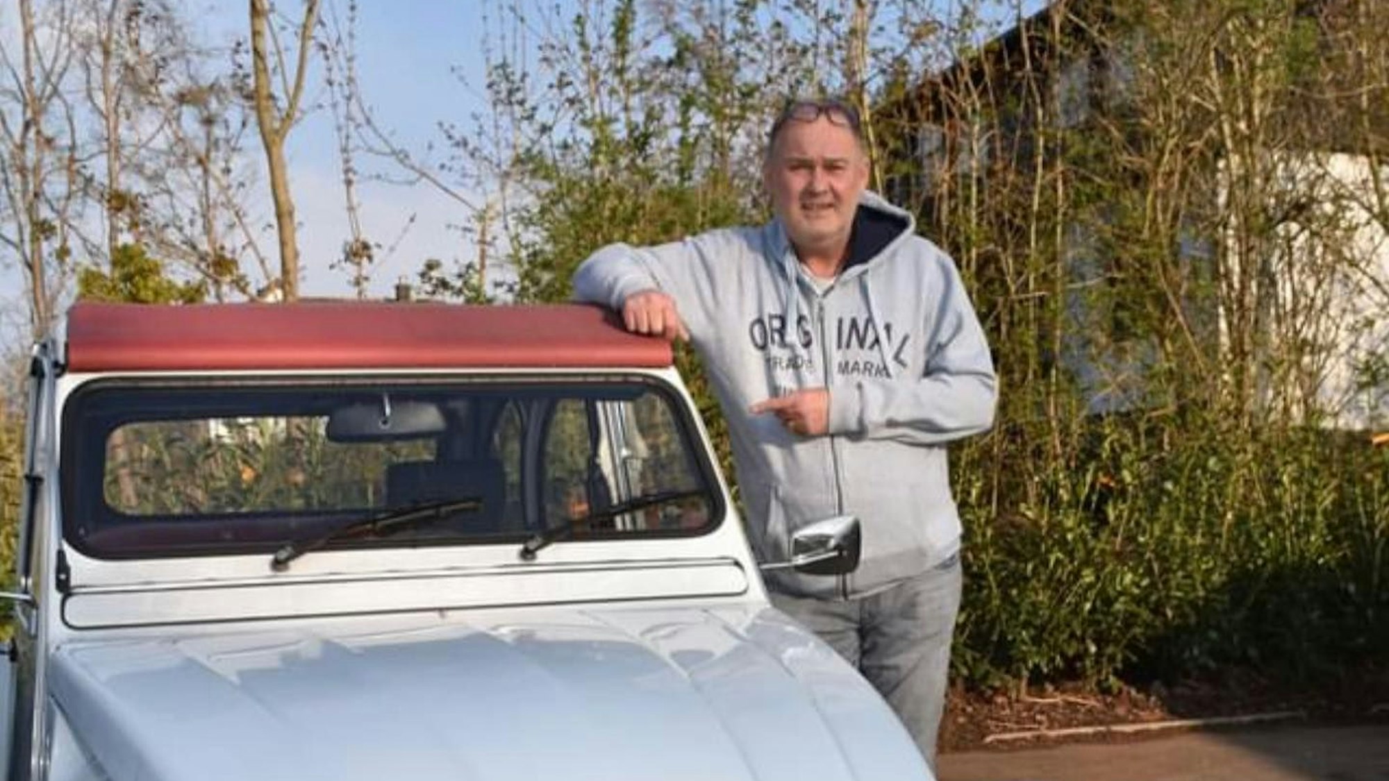 Auf dem Foto steht Waldi neben einem hellblauen Oldtimer und schaut in die Kamera.