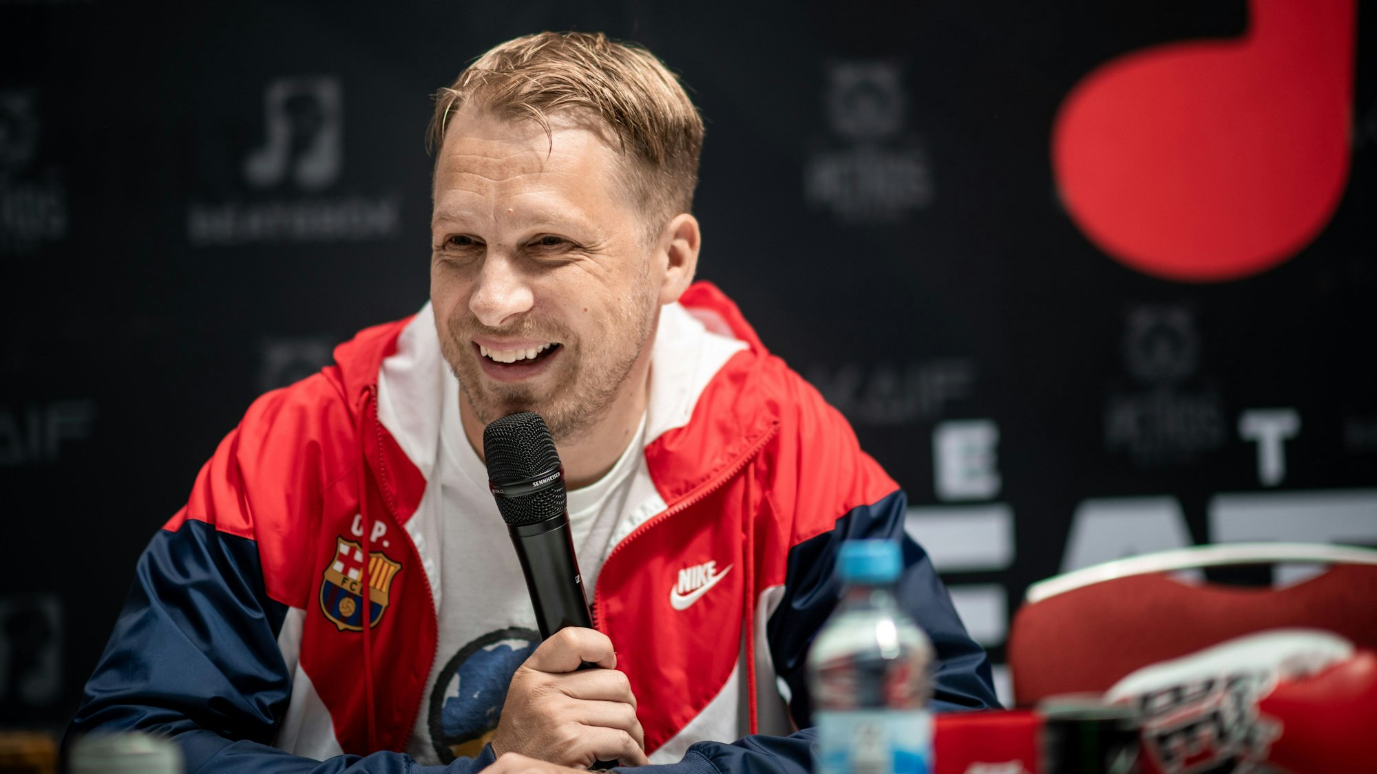 Oliver Pocher sitzt bei der Pressekonferenz im Westfield Centro in Oberhausen auf einer Bühne.