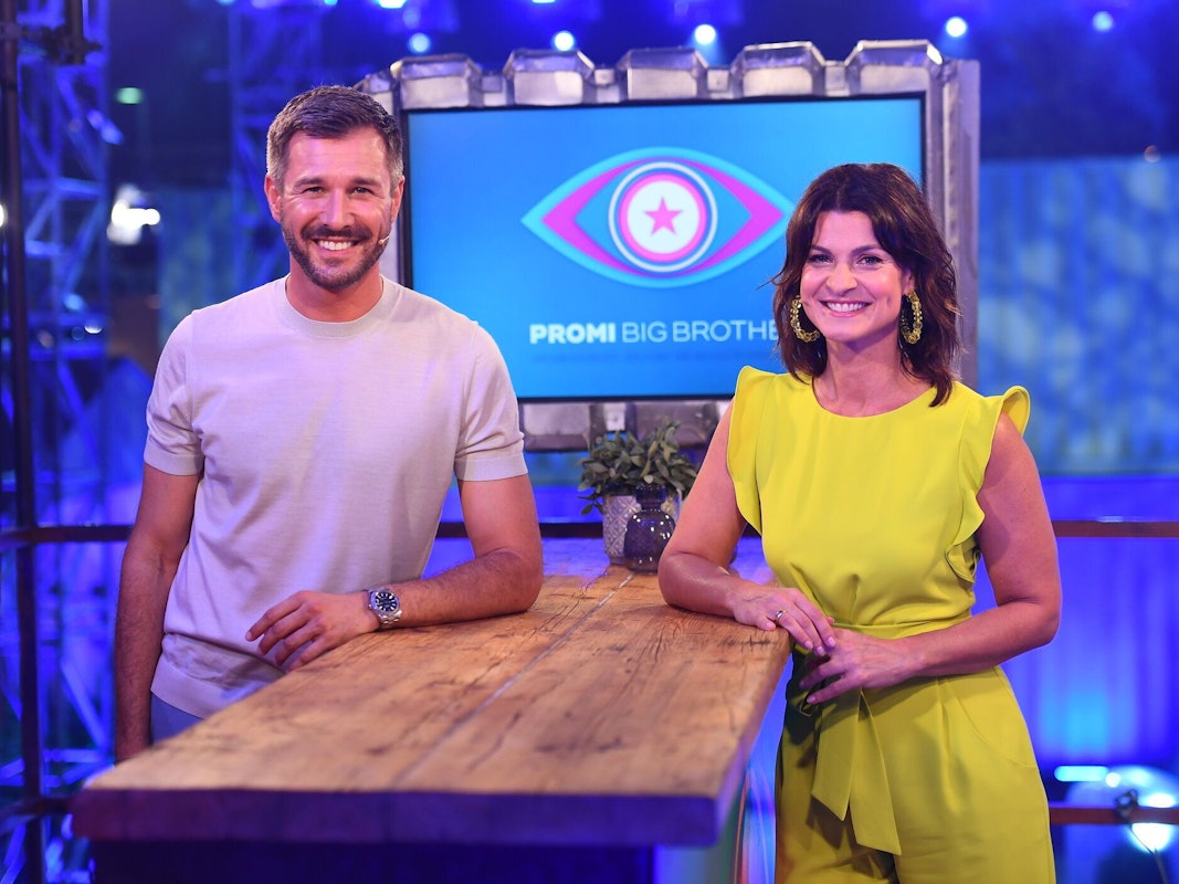 Die Moderatoren Jochen Schropp und Marlene Lufen, hier im Studio vor dem Logo der Sendung „Promi Big Brother“ im Juni 2020, werden auch in diesem Jahr die neue Staffel live bei Sat.1 moderieren.