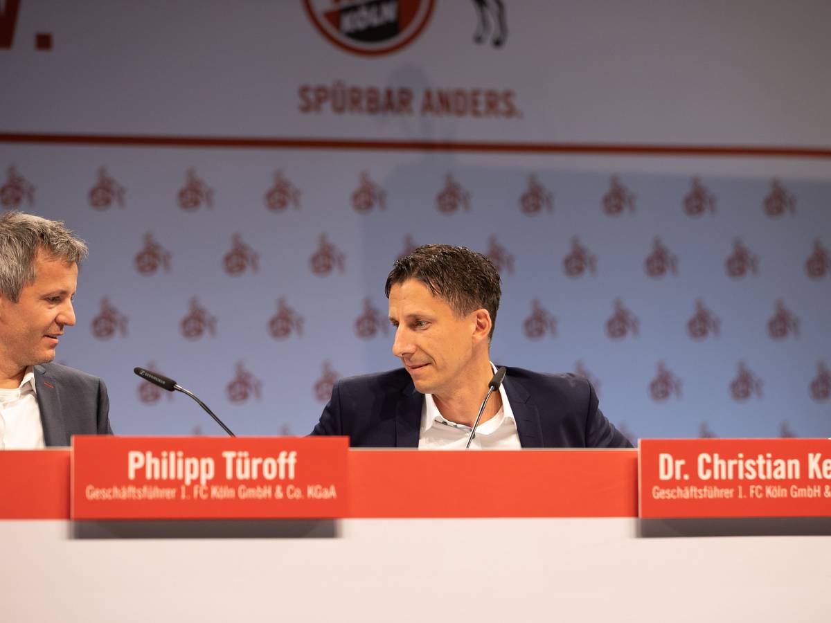 Philipp Türoff und Christian Keller sitzen bei der Mitgliederverammlung des 1. FC Köln auf dem Podium.