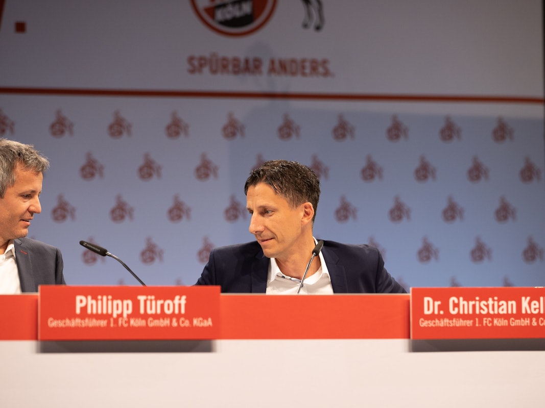 Philipp Türoff und Christian Keller sitzen bei der Mitgliederverammlung des 1. FC Köln auf dem Podium.
