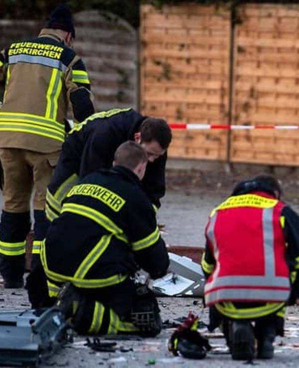 Kräfte der Löschgruppe Flamersheim sammeln Geldscheine, die auf dem Boden liegen, ein.