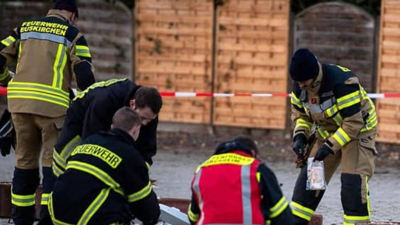 Kräfte der Löschgruppe Flamersheim sammeln Geldscheine, die auf dem Boden liegen, ein.
