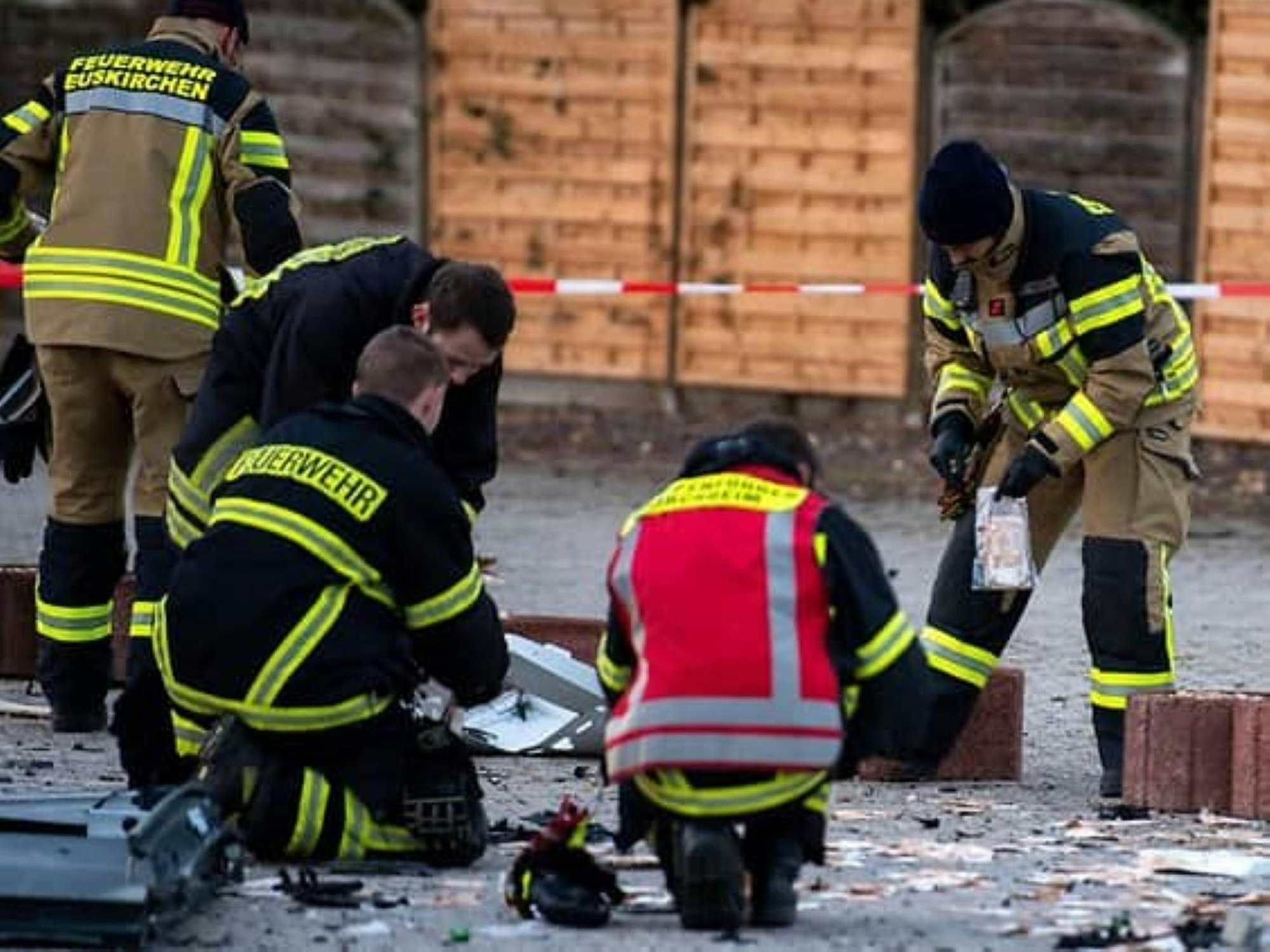 Kräfte der Löschgruppe Flamersheim sammeln Geldscheine, die auf dem Boden liegen, ein.