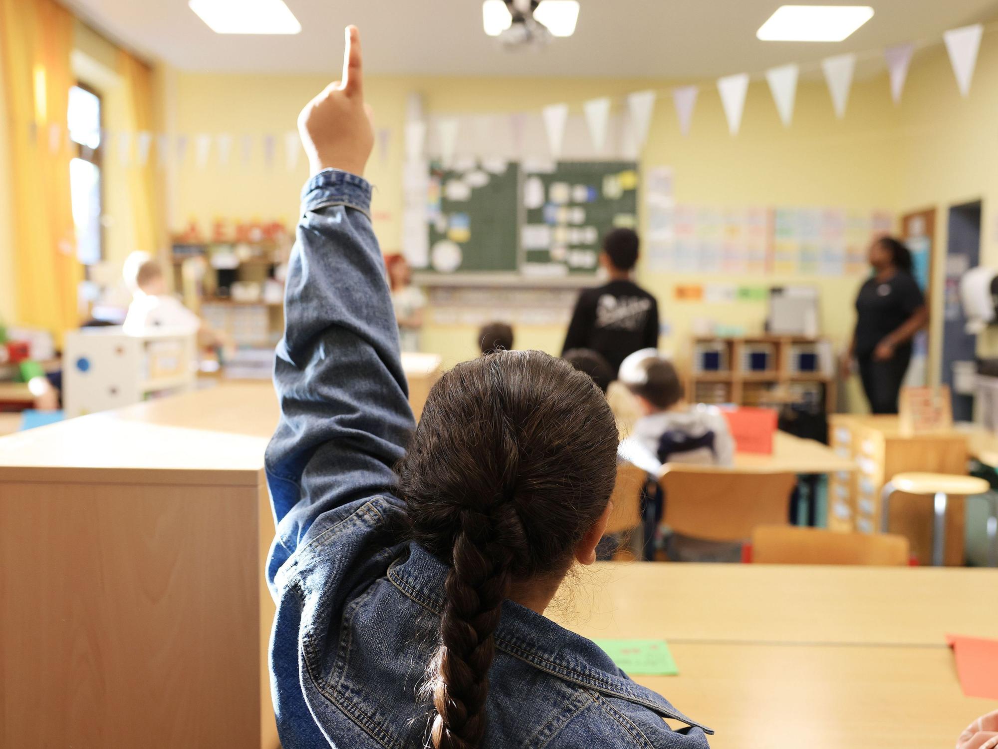 Eine Schülerin zeigt in der Grundschule Feldstraße im Unterricht auf.