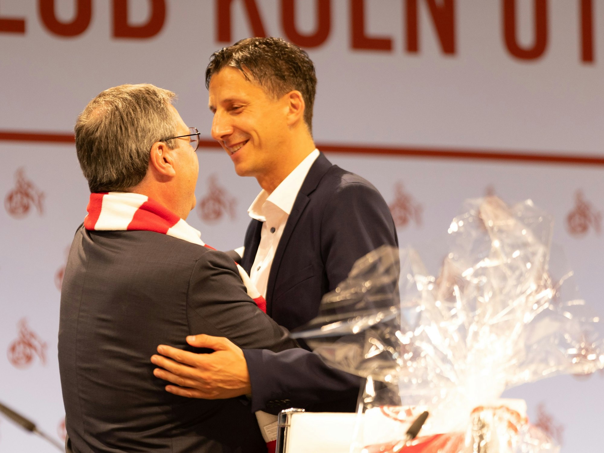 Dr. Werner Wolf (Vorstand) und Dr. Christian Keller (Geschäftsführer 1. FC Köln) umarmen sich bei der Mitgliederversammlung des 1. FC Köln.