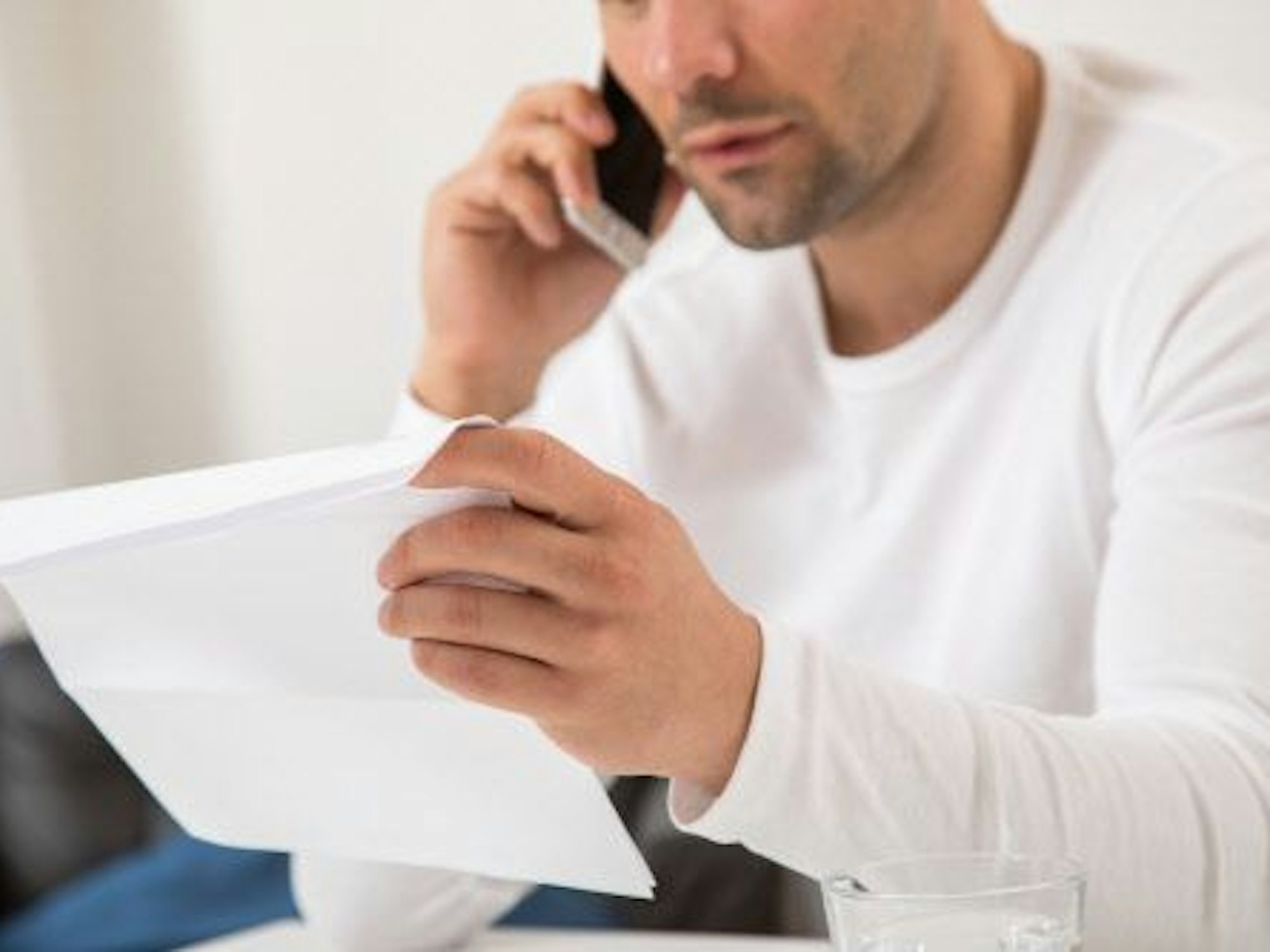 Das undatierte Symbolbild zeigt einen telefonierenden Mann, der seine Versicherungsangelegenheiten organisiert.