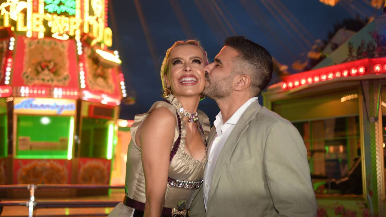 Verena Kerth und Marc Terenzi feiern auf dem Oktoberfest. Auf dem Foto küsst Marc seine Freundin auf die Wange. Verena strahlt in einem goldfarbenen Dirndl, Marc im beigen Jackett.