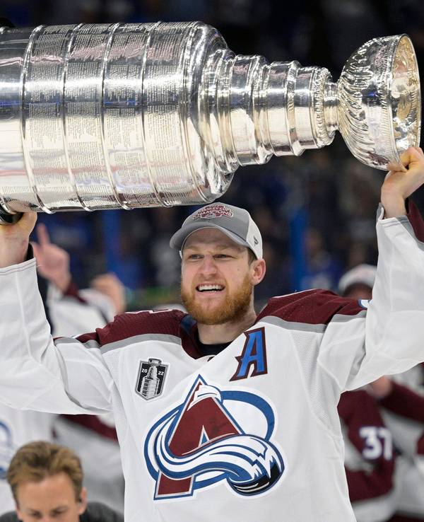 Nathan MacKinnon von den Colorado Avalanche reckt den Stanley Cup mit beiden Händen in die Höhe.