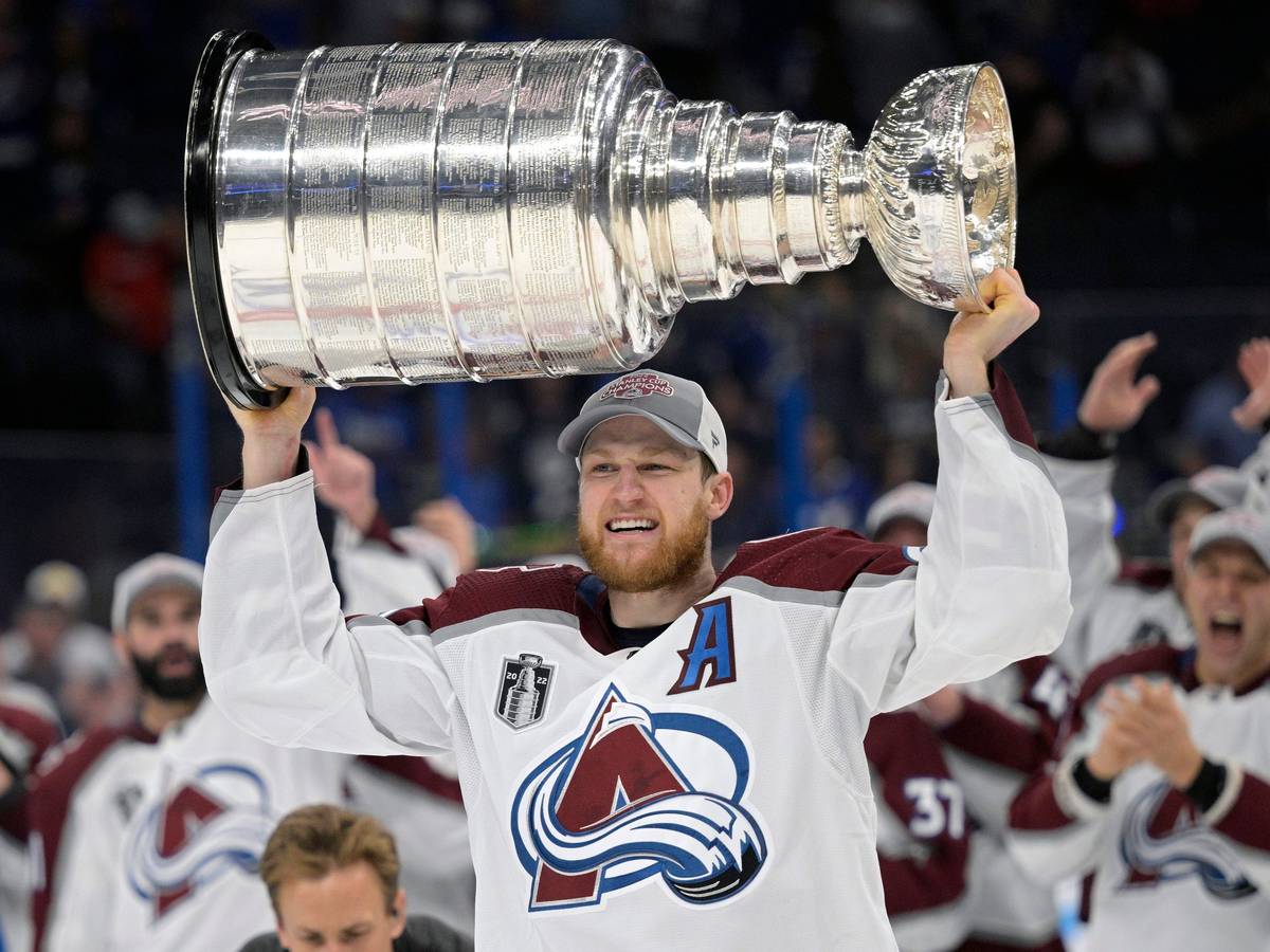 Nathan MacKinnon von den Colorado Avalanche reckt den Stanley Cup mit beiden Händen in die Höhe.