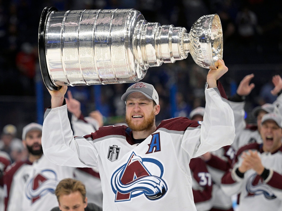 Nathan MacKinnon von den Colorado Avalanche reckt den Stanley Cup mit beiden Händen in die Höhe.