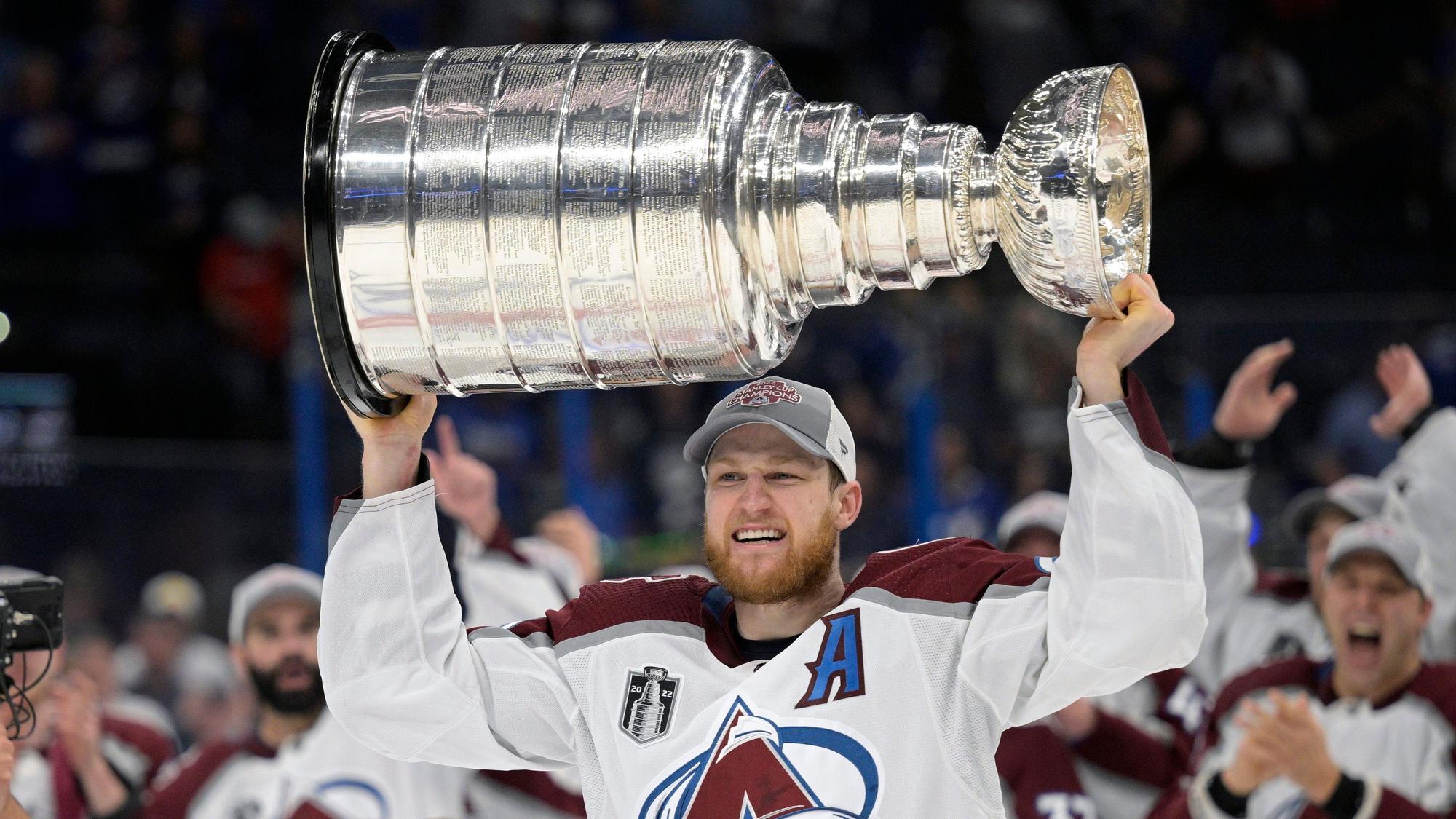 Nathan MacKinnon von den Colorado Avalanche reckt den Stanley Cup mit beiden Händen in die Höhe.