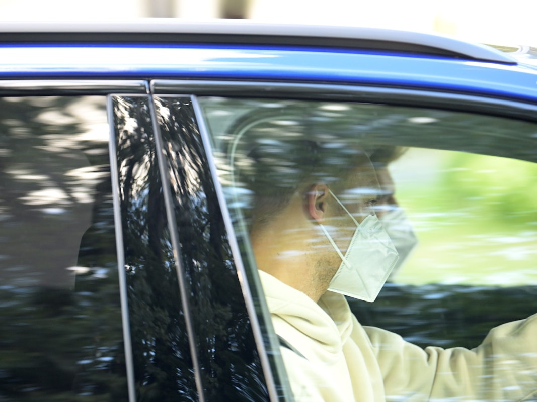 Nationaltorhüter Manuel Neuer sitzt mit Mund-Nasen-Schutz in einem wegfahrenden Auto.