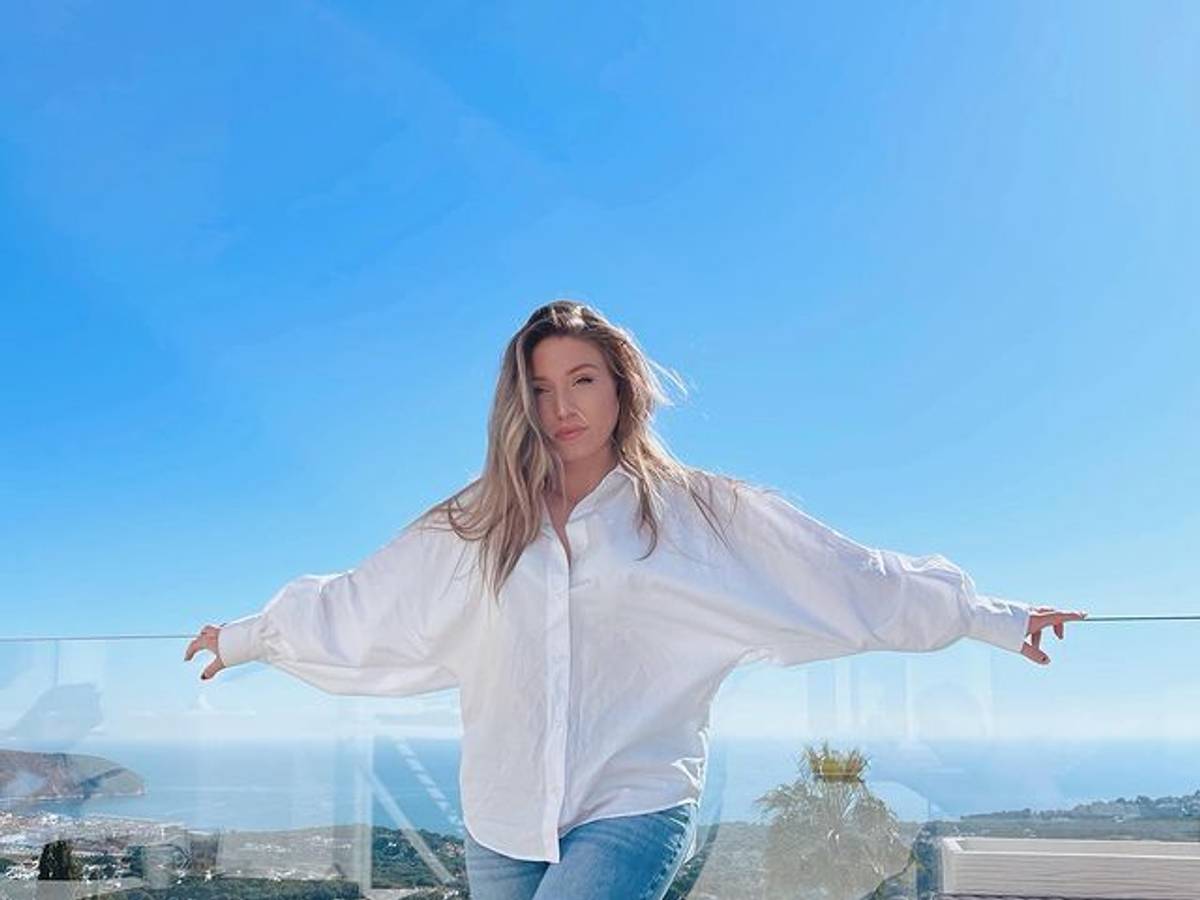 Biancas Noch-Ehemann Julian Claßen verrät im Interview, wie es der YouTuberin, hier auf einem Instagram Foto von Februar 2022, wirklich geht. Auf dem Foto steht Bianca in Jeans und weißer Bluse vor einer Glas-Ballustrade. Im Hintergrund ist das Meer zu sehen.