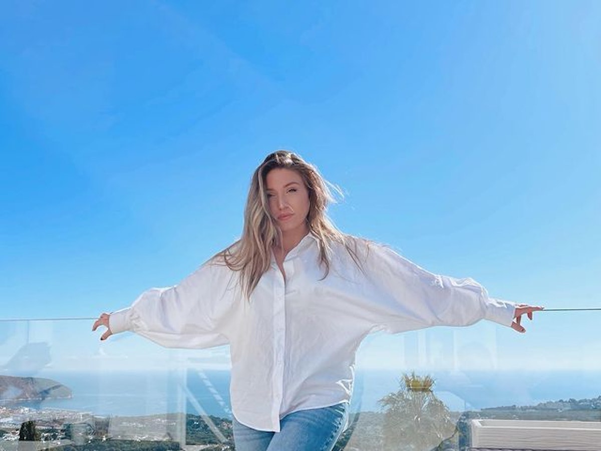 Biancas Noch-Ehemann Julian Claßen verrät im Interview, wie es der YouTuberin, hier auf einem Instagram Foto von Februar 2022, wirklich geht. Auf dem Foto steht Bianca in Jeans und weißer Bluse vor einer Glas-Ballustrade. Im Hintergrund ist das Meer zu sehen.