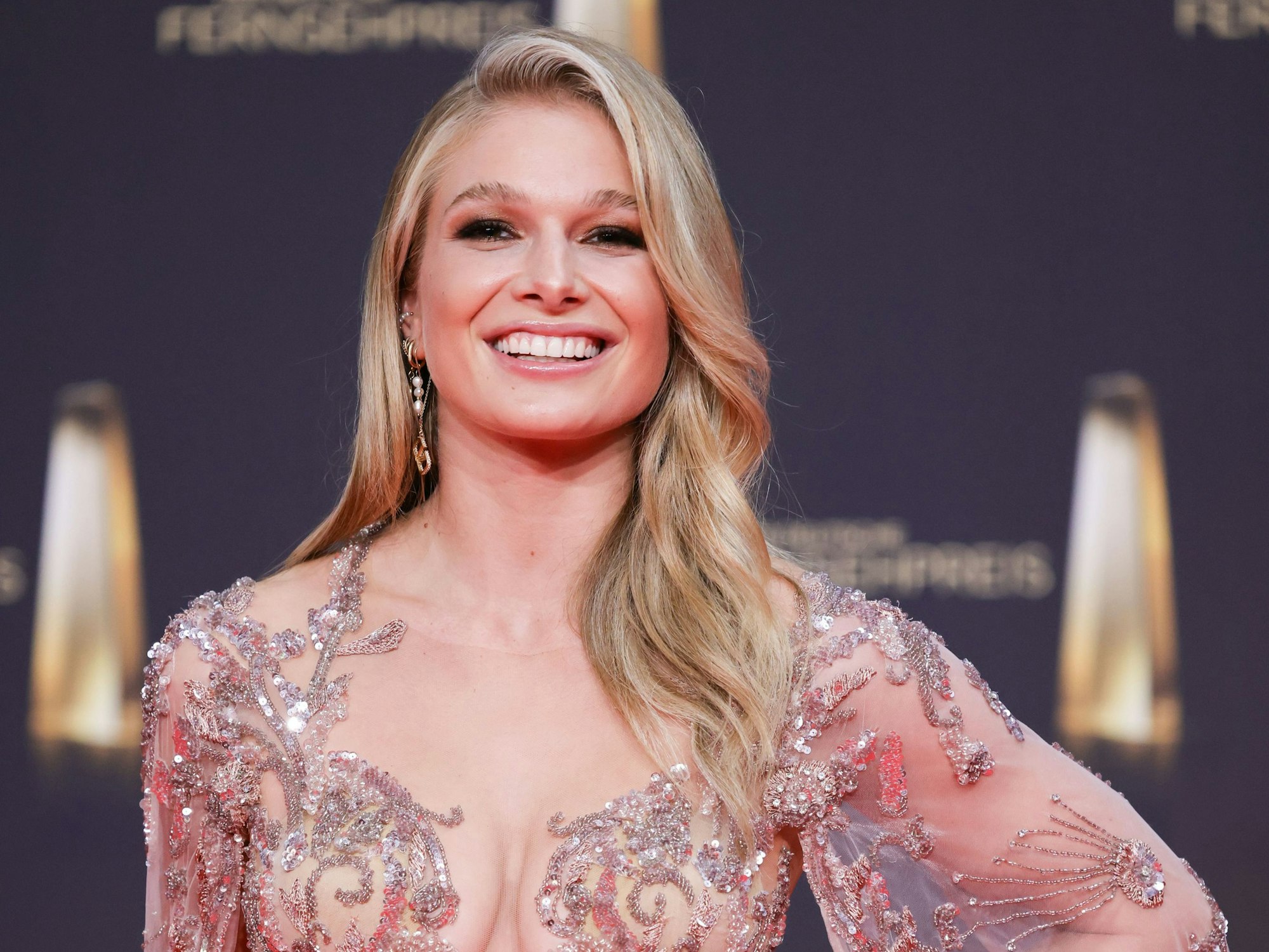 Top gestylt präsentiert sich Lola Weippert beim Deutschen Fernsehpreis am 14. September 2022 in einem langen, glitzernden Kleid.
