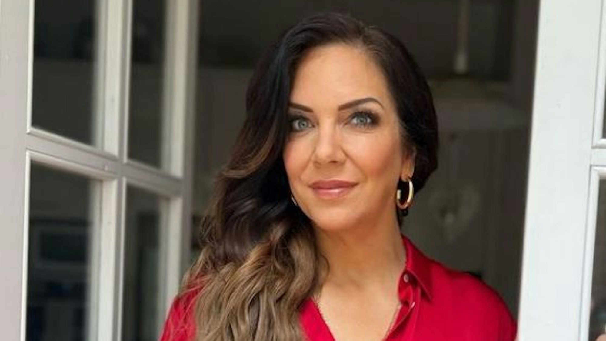 Danni Büchner posiert in einem roten Oberteil für die Kamera.