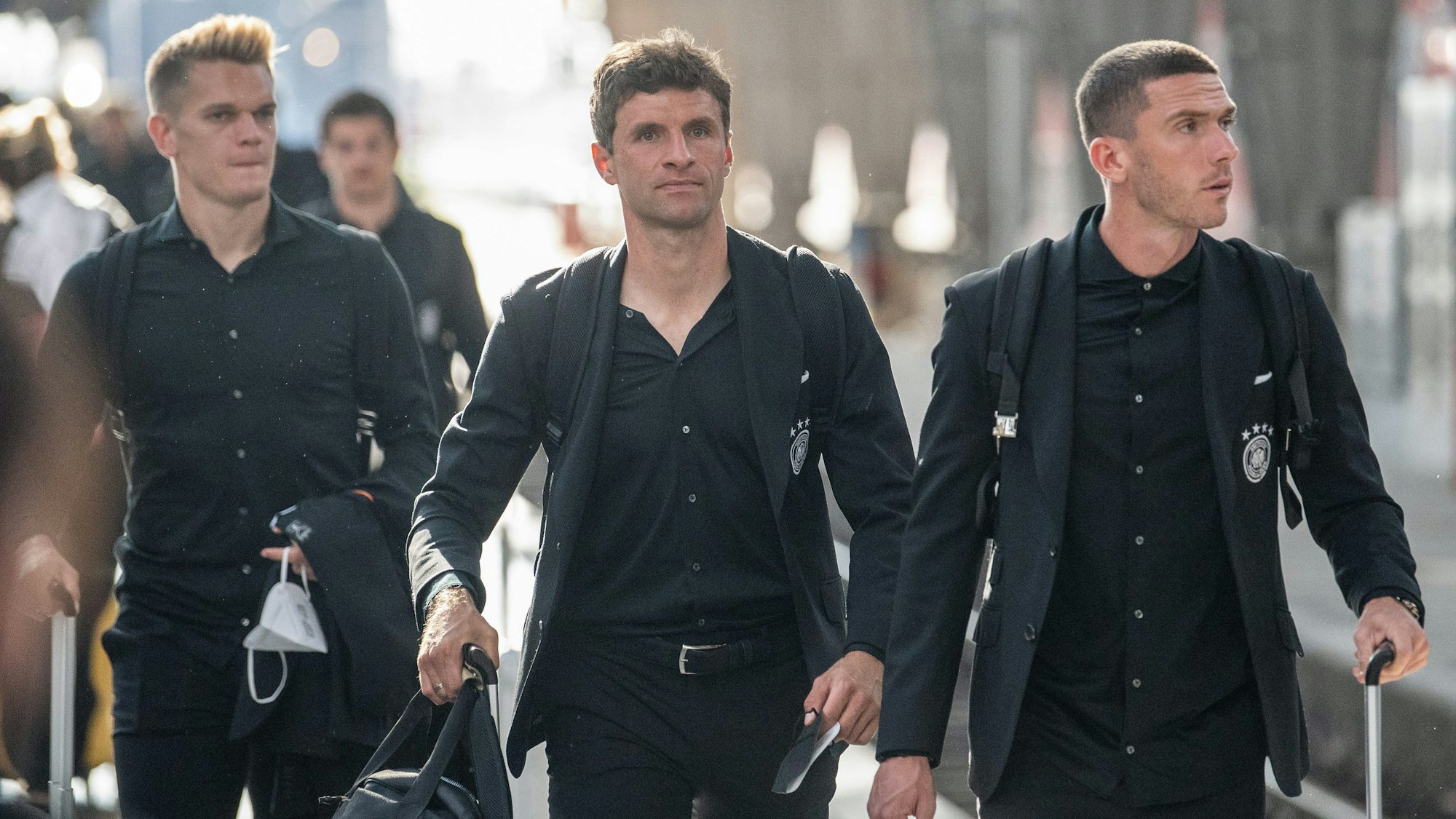 Die Nationalspieler Matthias Ginter (l-r), Thomas Müller und Robin Gosens kommen zum Gleis.