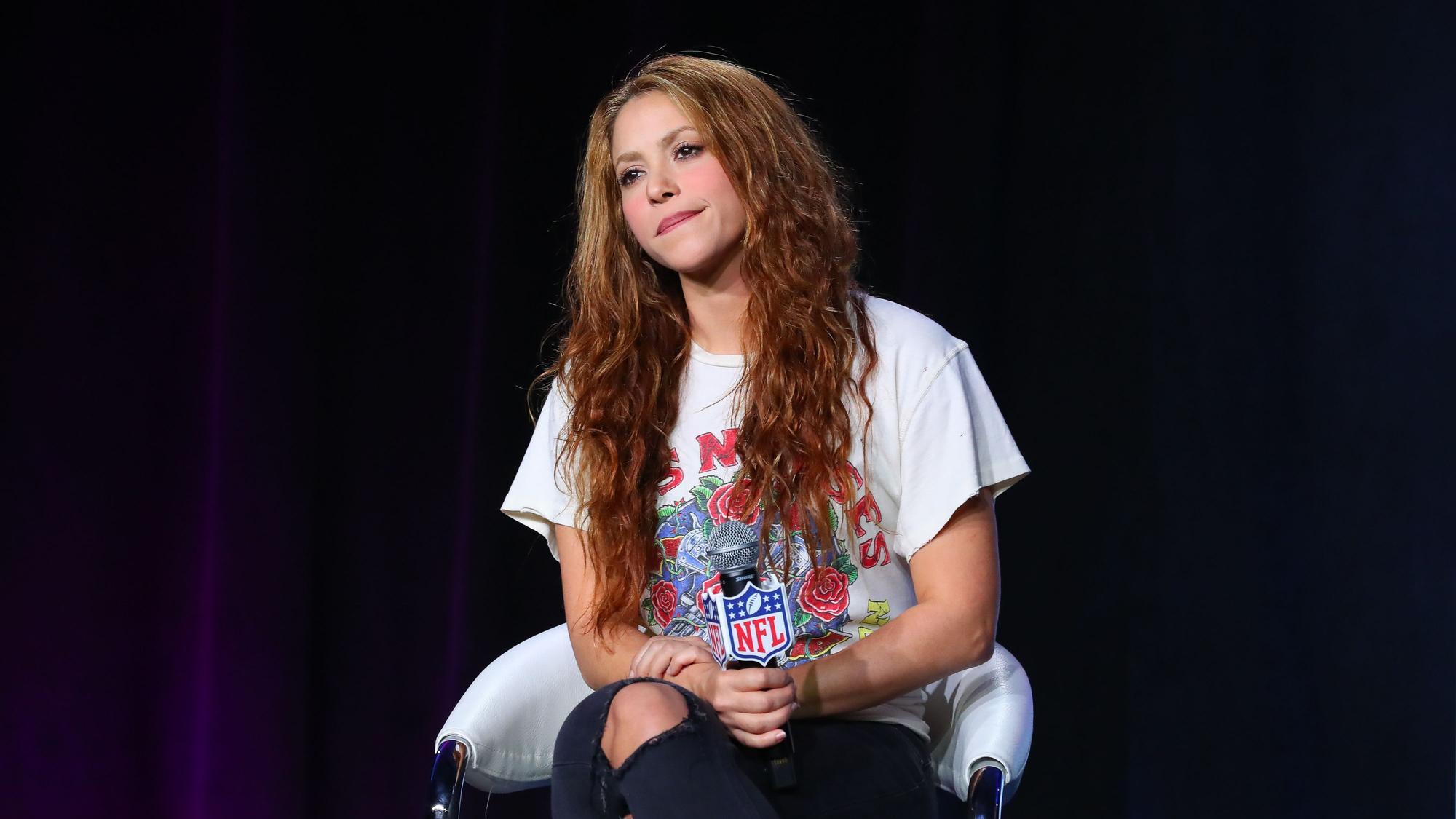 Shakira sitzt auf einem Stuhl.
