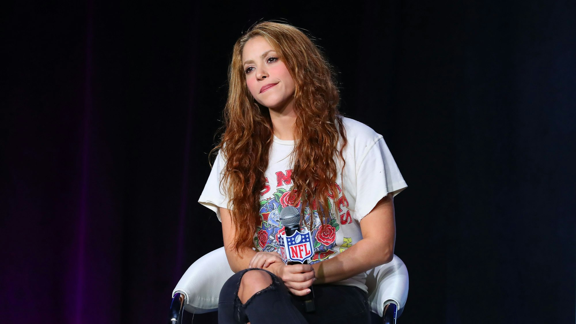 Shakira sitzt auf einem Stuhl.